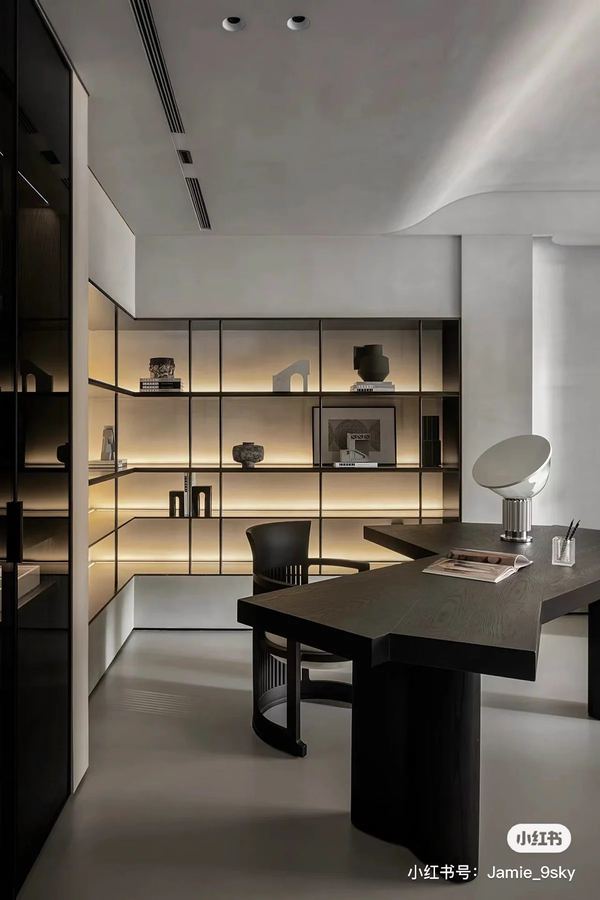 Office space with floor-to-ceiling blackened steel grid shelving, warm LED backlit cells, dark stained oak desk